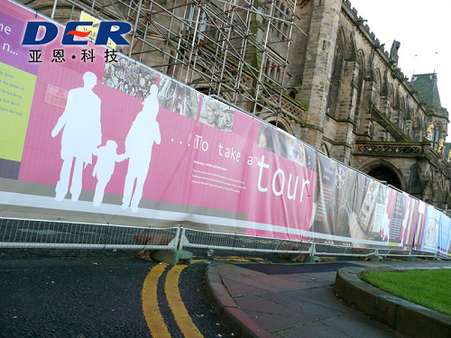 Large printed mesh banner installed on outdoor construction fence